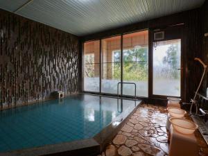 a swimming pool with toilets and a large window at Hayamasou in Tokamachi