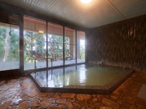 una grande piscina d'acqua in una stanza con finestra di Hayamasou a Tokamachi