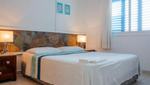 a bedroom with a large bed with two white pillows at Pissouri Beach Apartments in Pissouri