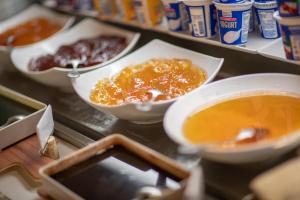 a counter with bowls of food and a bowl of soup at Pergola Hotel & Spa in Mellieħa