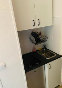 a small kitchen with a sink and a counter at Studio quartier chic centre Paris tout équipé in Paris