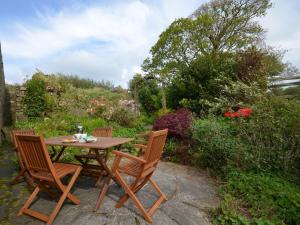 a wooden table and chairs on a patio at 2 Bed in Tintagel 51184 in Lanteglos