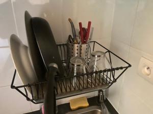 a basket of kitchen utensils is hanging over a sink at Studio quartier chic centre Paris tout équipé in Paris