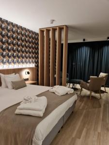 een slaapkamer met een groot bed en handdoeken bij MY HOTEL MALMEDY in Malmedy