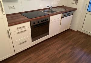 a kitchen with a sink and a stove at Rentarooms A in Oebisfelde