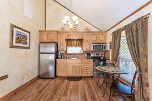a kitchen with wooden cabinets and a stainless steel refrigerator at Appian Way Tuscan Cottage in Fredericksburg