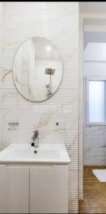 een witte badkamer met een wastafel en een spiegel bij Sweet dreams Parking by request in Sofia