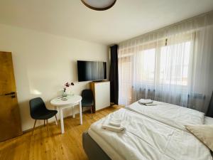 Schlafzimmer mit einem Bett, einem Tisch und einem TV in der Unterkunft Apartmán č.4 v bankovním domě in Kutná Hora