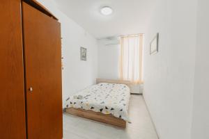 een kleine slaapkamer met een bed en een raam bij Apartament Piata Amzei 1 (17 B) in Boekarest