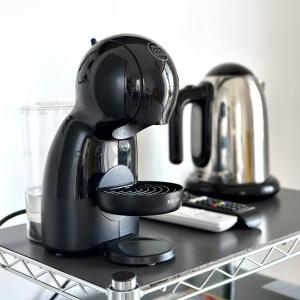 a black coffee maker sitting on top of a shelf at Villa Flora, Piscina Esclusiva e Mare in Brucoli +10 photos