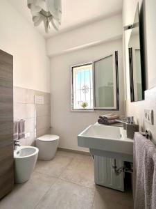 Baño blanco con lavabo y aseo en Villa Flora, Piscina Esclusiva e Mare, en Augusta