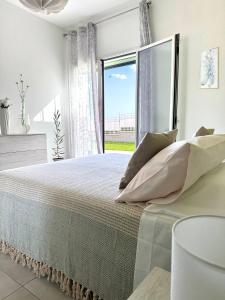 a bedroom with a large bed with a large window at Villa Flora, Piscina Esclusiva e Mare in Brucoli