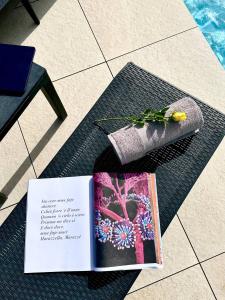 un libro sentado en una mesa junto a una mesa Sidx Sidx en Villa Flora, Piscina Esclusiva e Mare, en Augusta