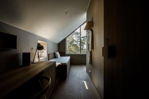 a small room with a bed and a window at Hilltop Forest in Inkoo