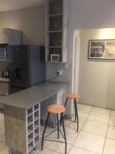 a kitchen with two stools and a counter top at Euphoria in Nelspruit