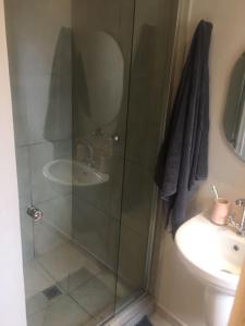 a bathroom with a glass shower and a sink at Euphoria in Nelspruit
