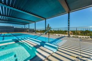 a large swimming pool with chairs in a building at Seaside Garden Apartments & Wellness by Baltic Apartments in Świnoujście