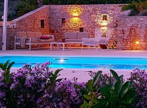 a pool with chairs and a table and a stone building at Villa Bacio with heated pool, starlink internet in Brštanovo