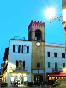 un edificio con una torre dell'orologio sopra di B&B La Loggia e L’Orologio a Castiglione del Lago