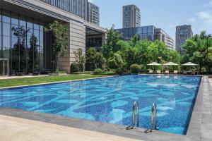 a swimming pool in front of a building at Sheraton Qingdao Jiaozhou Hotel in Jiaozhou