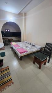 een slaapkamer met een groot bed en een stoel bij Banaras Gully House 500 ft from The Ghats in Varanasi