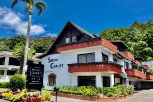 a hotel with a sign in front of a building at The Swiss Chalet Apartment 9 - Seaview - Top Floor - Air Conditioning & Wi-Fi - Bay of Islands in Paihia