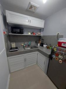 a small kitchen with a sink and a refrigerator at Transient in Bria Homes in General Santos