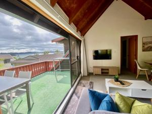 a living room with a view of a patio with a tv at The Swiss Chalet Apartment 9 - Seaview - Top Floor - Air Conditioning & Wi-Fi - Bay of Islands in Paihia