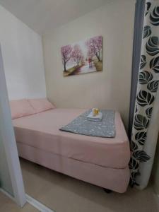 a small bedroom with a bed and a painting on the wall at Transient in Bria Homes in General Santos