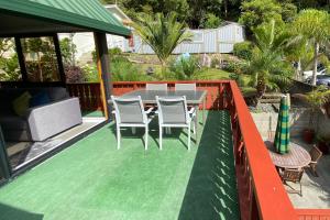 a patio with a table and chairs on a deck at The Swiss Chalet Apartment 9 - Seaview - Top Floor - Air Conditioning & Wi-Fi - Bay of Islands in Paihia