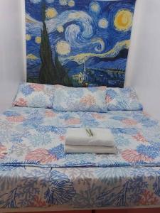Transient in Bria Homes في جنرال سانتوس: سرير عليه منشفة عليها لوحة