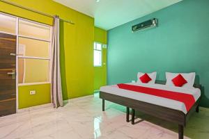 een slaapkamer met een bed met rode en groene muren bij OYO Flagship Hotel Arya Residency in Gurgaon