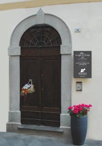 una puerta a un edificio con un cartel y flores en B&B La Loggia e L’Orologio, en Castiglione del Lago