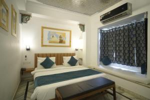 a bedroom with a bed and a window at Banjara Retreat in Udaipur
