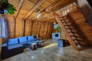 a living room with a blue couch and a wooden wall at Domki Na Grapie in Międzybrodzie Bialskie