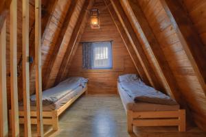 a room with two beds in a wooden cabin at Domki Na Grapie in Międzybrodzie Bialskie