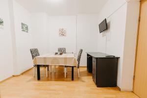 una sala da pranzo con tavolo, sedie e TV di Apartament Piata Amzei 1 (17 B) a Bucarest