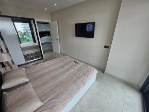 a room with a bed and a tv on the wall at Konak Tower Seaside mahmutlar in Alanya
