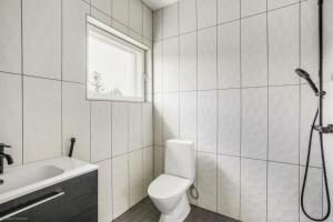 baño con aseo y lavabo y ventana en Uusi huvila Lahdessa en Lahti