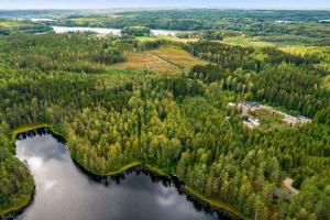 uma vista aérea de uma floresta e de um lago em Uusi huvila Lahdessa em Lahti