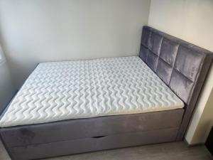 a bed in a room with a gray mattress at Uusi huvila Lahdessa in Lahti