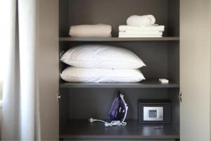 een plank met handdoeken en kussens in een kamer bij Hector Luxury Suite in Athene
