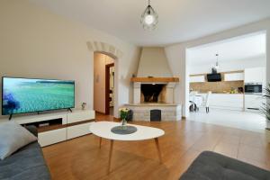 een woonkamer met een tv, een bank en een tafel bij Villa Natali with private pool and kids playground near Fažana in Galižana