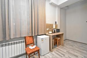 a room with a kitchen with a refrigerator and a table at Komitas Residence in Yerevan