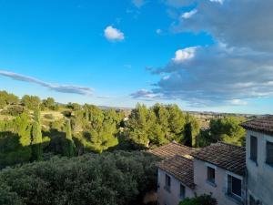 uma vista para o campo a partir do telhado de uma casa em Les Garrigues de la Vallée des Baux em Paradou