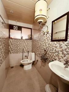 La salle de bains est pourvue de toilettes et d'un lavabo. dans l'établissement Green Lodge Farmstay by Highland Monk, à Shimla