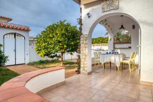 a patio with an archway with a table and a tree at Falguera in L'Escala