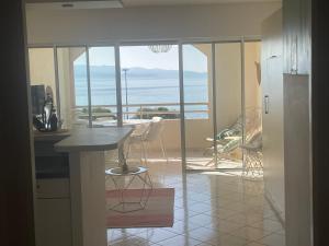 a kitchen with a table and a view of the ocean at Superbe Pieds dans l eau ajaccio face à la mer plage de sable fin route des îles des sanguinaires in Ajaccio