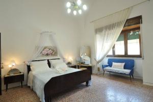 - une chambre avec un grand lit et une chaise dans l'établissement Appartamento Zii Mpeu by Salentoaffitti, à Racale