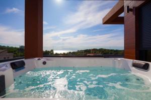 プレマントゥーラにあるLuxury Villa ReMi near Medulin with wellness and sea viewの大きな窓付きの客室で、ジャクジータブが備わります。